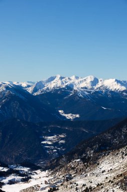 Berrak mavi gökyüzünün altında sersemletici kar örtülü dağlar. Yüksek kalite.