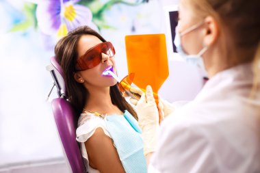 Diş çürükleri önleme genel bakış. Diş ameliyatı sırasında dişçi koltuğunda ki kadın. Güzel Kadın gülümseme 