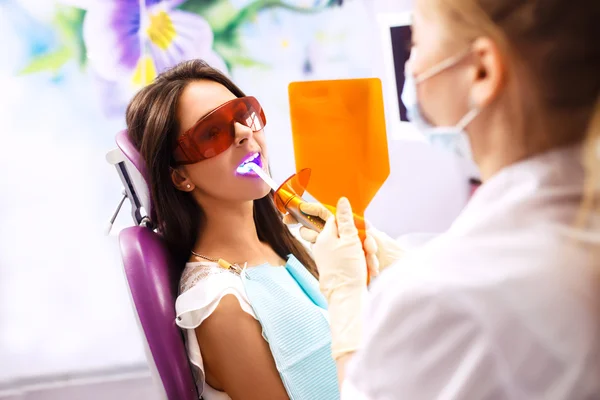 Panoramica della prevenzione della carie dentale.Donna sulla sedia del dentista durante una procedura dentale. Bella donna sorriso — Foto Stock