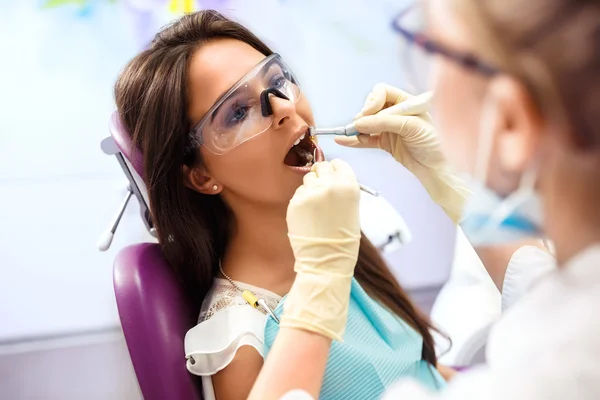 Oversikt over forebyggende karies hos tannlege Kvinne i tannlegestol under tannbehandling . stockbilde