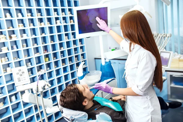 Oversikt over forebygging av karies. mann i tannlegestolen under tannbehandling . stockbilde