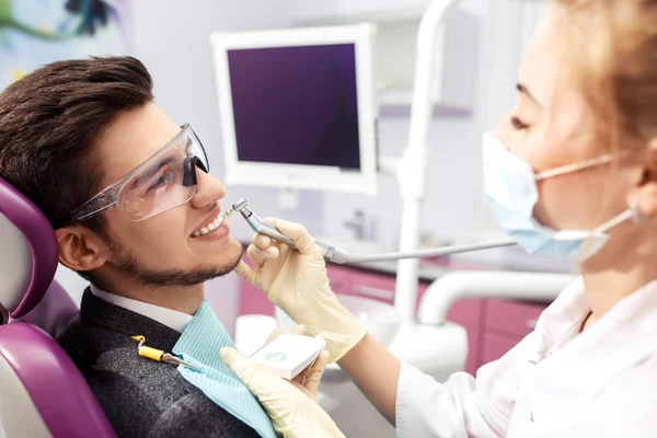 Vue d'ensemble de la prévention de la carie dentaire.homme à la chaise du dentiste pendant une procédure dentaire. Beau sourire homme — Photo