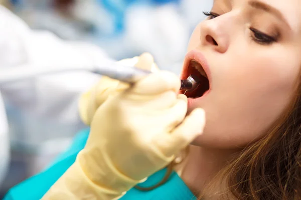 Översikt av tand karies förebyggande. Kvinna vid tandläkarstolen under ett tandingrepp. — Stockfoto