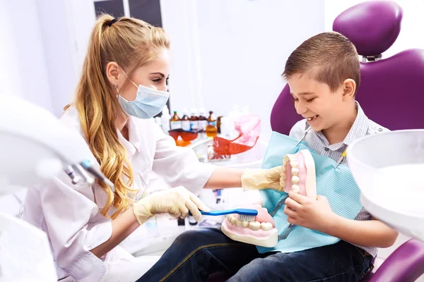 Dentysta pokazuje protezy do małego chłopca. Chłopiec z uśmiechem. — Zdjęcie stockowe