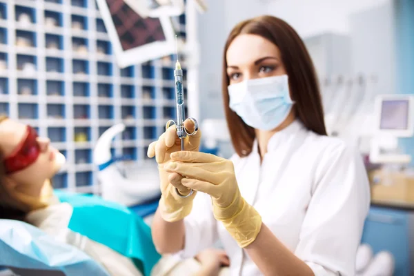 Spuit. een injectie. dichtgeschroeid. Portret van vrouwelijke tandarts op kantoor. Dental Care concept. — Stockfoto