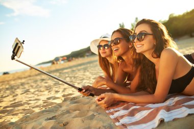 yaz tatil ve tatil - selfie telefon yapıyor beach.girls güneşlenme kızlar. Yaz saati tadını çıkarın. Plajda eğlence. Büyük yaz ruh. güneşli gün