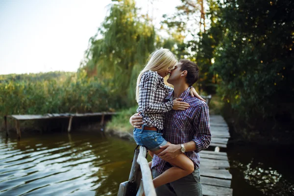 Ein junges Paar küsst sich im Park bei Sonnenaufgang — Stockfoto