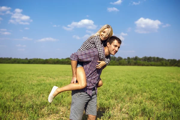 Casal feliz está correndo juntos no campo verde — Fotografia de Stock