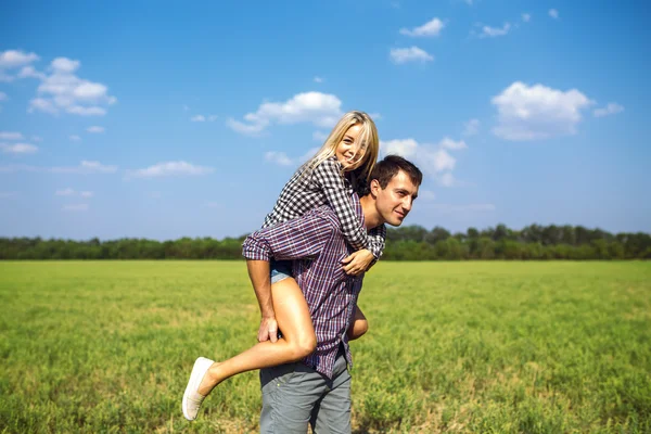 Heureux couple court ensemble dans le champ vert — Photo