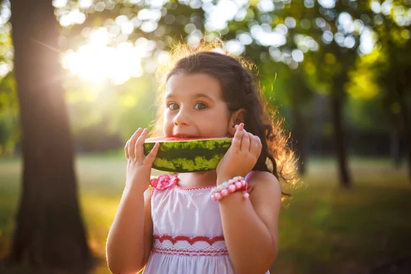 Criança engraçada comendo melancia ao ar livre no parque de verão, foco nos olhos. Criança, bebé, comida saudável. Estilo de vida juvenil . — Fotografia de Stock