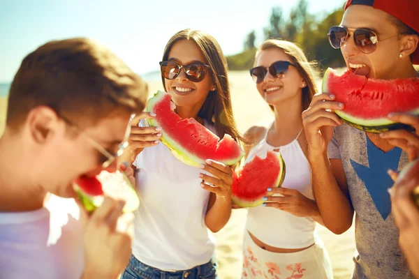 若い人たちは ビーチでスイカを食べるします 夏の時間をお楽しみください ビーチで楽しい 素晴らしい夏気分 晴れた日 — ストック写真