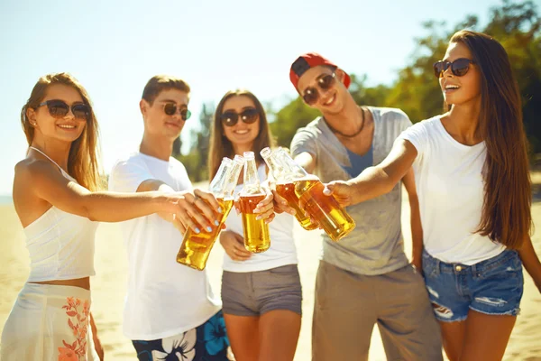 young People clinking glasses with beer. People Celebration Beach Party Summer Holiday Vacation Concept. enjoy summer time. Fun at the beach. Great summer mood. sunny day