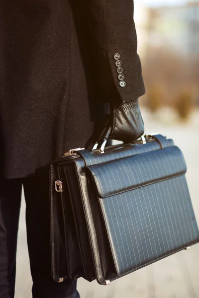 Maletín de cuero en su mano. joven hombre de negocios — Foto de Stock