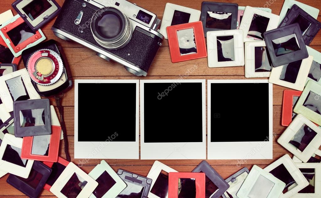 Film photos on the table. retro camera and some old photos on wooden table. 