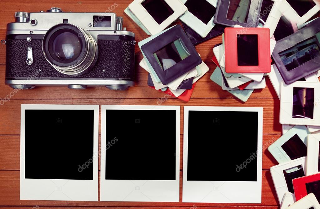 Film photos on the table. retro camera and some old photos on wooden table. 