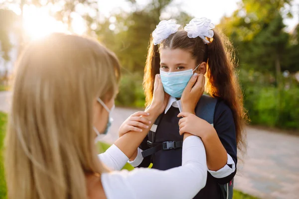 Caring Mother Helps Wear Medical Mask Schoolgirl Outdoors School Covid — Stock Photo, Image