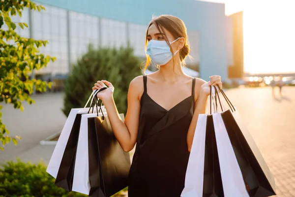Gyönyörű Védő Orvosi Maszkban Bevásárlószatyrokkal Pláza Közelében Sétálva Naplementekor Bevásárlás — Stock Fotó