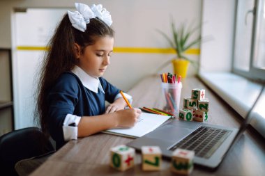 Evdeki online dersi sırasında ev ödevi okuyan şık bir öğrenci. Kendini izole etme, online eğitim konsepti, evde eğitim. Covid 2019.