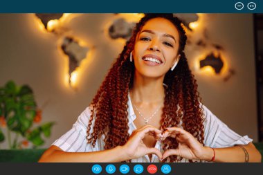 Kafede oturan ve dizüstü bilgisayarında video görüşmesi yapan Afro-Amerikan bir kadının portre portresi. İş kadını müşterisiyle Webcam konferansında konuşuyor. 
