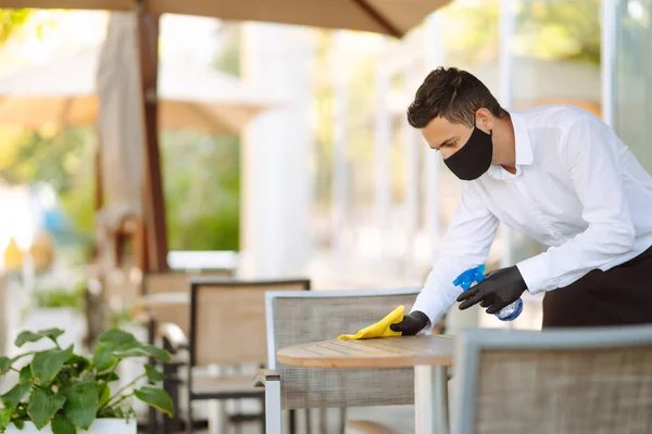 Camarero Mascarilla Protectora Guantes Limpiando Mesa Con Spray Desinfectante Restaurante — Foto de Stock