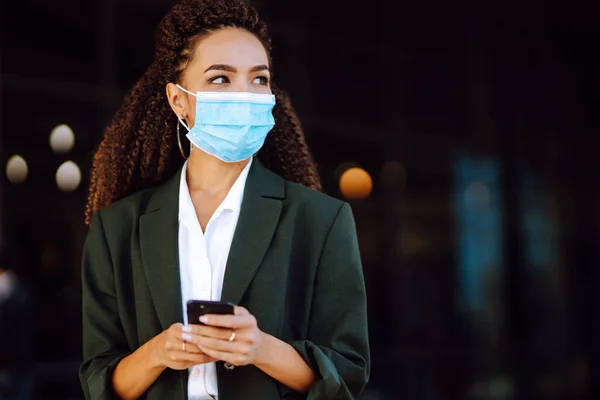 Telefonu Kullanarak Tıbbi Maske Takan Güzel Bir Kadını Koronavirüs Salgını — Stok fotoğraf