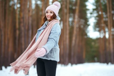 Ormanda eğlenen genç bir kadının portresi. Kış anlarından zevk alan gülümseyen kadın. Noel, Yeni Yıl.