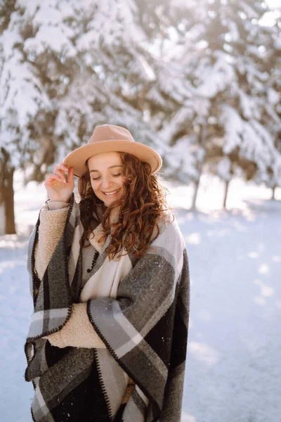 微笑的女人在雪地的公园里享受着冬天的时光 穿着帽子 格子花围巾和外套的年轻女子 冬季时尚 圣诞节假期的概念 — 图库照片