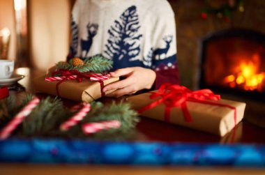 Erkeklerin elleri Noel hediyesini tutuyor. Noel hediyesi olarak kırmızı kurdele ve yeşil köknar dalı kullanan bir adam. Wintar tatili.               