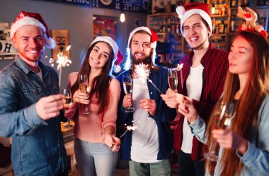 Kutlama sırasında ellerinde maytap olan genç ve mutlu bir kalabalık. Bir grup mutlu arkadaş eğleniyor. Bengal ateşlerinin ışıltılı ışıkları 2021.