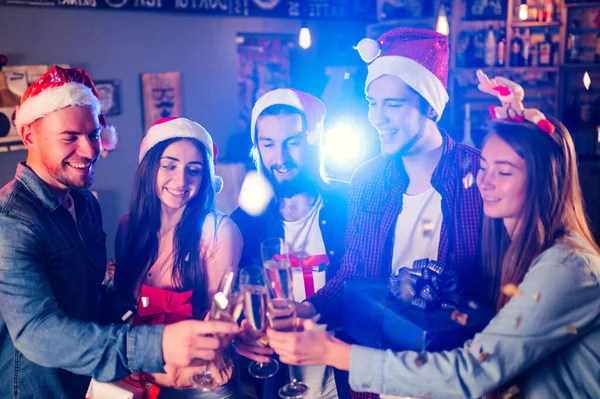 新年のパーティーを祝う幸せな友人のグループ キラキラとギフトやクリンクガラスを持つ若い人たちの群衆 パーティー ナイトライフ クリスマス — ストック写真