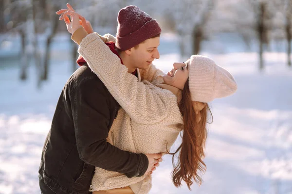겨울철 공원의 야외에서 껴안고 입맞추는 눈덮인 속에서 남녀가 서로를 즐깁니다 — 스톡 사진