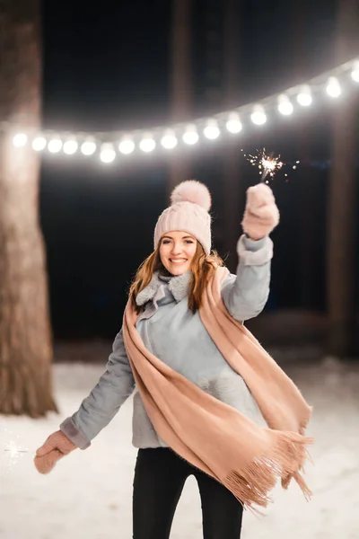 冬の森で輝きを持つ陽気な若い女性 お祭りのガーランドライト クリスマス — ストック写真