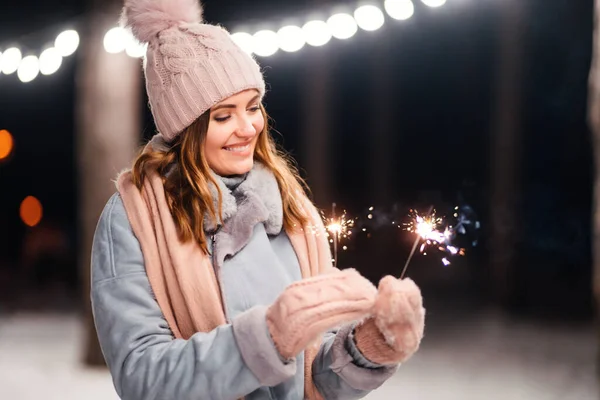 冬の森で輝きを持つ陽気な若い女性 お祭りのガーランドライト クリスマス — ストック写真