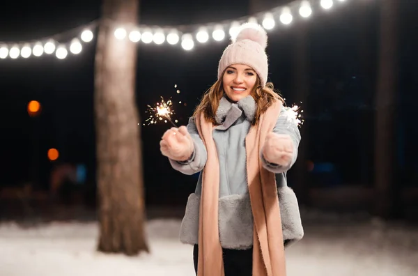 冬の森で輝きを持つ陽気な若い女性 お祭りのガーランドライト クリスマス — ストック写真