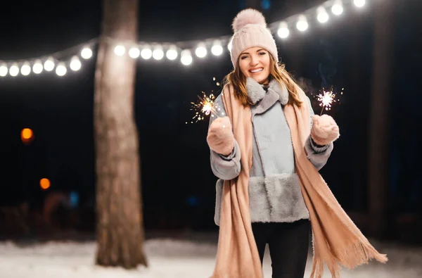 冬の森で輝きを持つ陽気な若い女性 お祭りのガーランドライト クリスマス — ストック写真