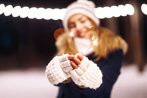 燃える輝きの花火を手に女性の手の優しい光 冬の森で輝きを持つ若い女性 お祭りのガーランドライト クリスマス ニューイヤーパーティー — ストック写真