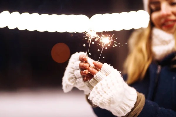 燃える輝きの花火を手に女性の手の優しい光 冬の森で輝きを持つ若い女性 お祭りのガーランドライト クリスマス ニューイヤーパーティー — ストック写真