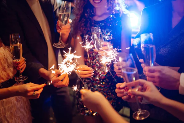手里拿着闪闪发光的火花 一群快乐的人在聚会上手握火花 年轻的朋友们在夜总会里碰杯香槟 庆祝活动 人与假日概念 — 图库照片