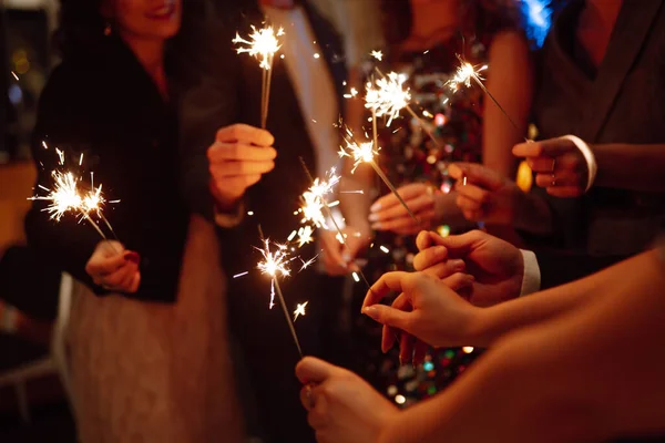手里拿着闪闪发光的火花 一群快乐的人在聚会上手握火花 年轻的朋友们在夜总会里碰杯香槟 庆祝活动 人与假日概念 — 图库照片