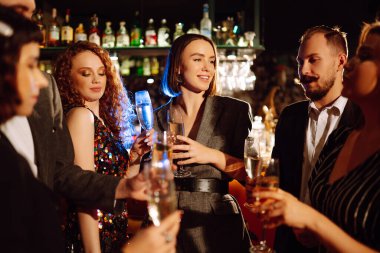 Bir grup mutlu insan partide maytap tutuyor. Genç arkadaşlar şampanya bardaklarını tokuşturup havai fişeklerle yeni yılın tadını çıkarıyorlar. Parti, kutlama, tatil konsepti.