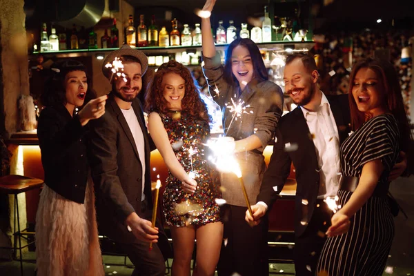 一群快乐的人在聚会上手握火花 年轻的朋友们一边喝着香槟 一边用烟火欢度新年的前夜 假日概念 — 图库照片