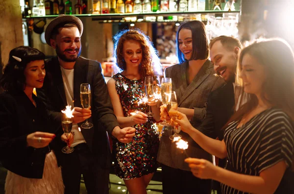 一群快乐的人在聚会上手握火花 年轻的朋友们一边喝着香槟 一边用烟火欢度新年的前夜 假日概念 — 图库照片