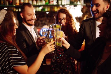 Mutlu arkadaşlar tezahürat yapıyor ve kokteyl içiyor. Partide eğleniyorlar. Bardaklarla bardaktan boşalırcasına içki içen bir grup genç. Gençlik, yaşam tarzı ve gece hayatı kavramı.