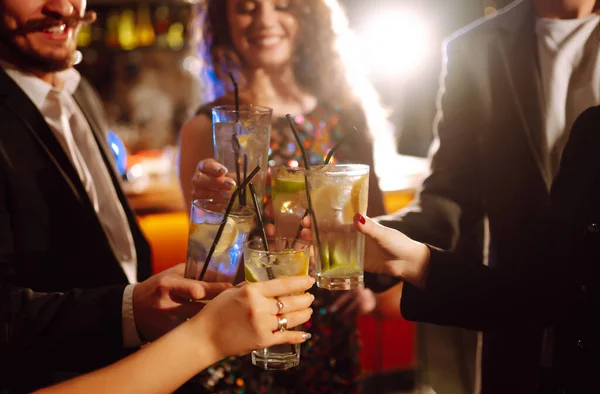 快乐的朋友们在俱乐部里欢呼雀跃 喝鸡尾酒 享受派对的乐趣 一群年轻人在酒吧里喝着鸡尾酒 在玻璃杯里叮当作响 生活方式和夜生活概念 — 图库照片