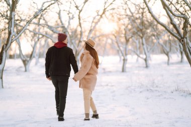 Genç çift kış tatilinde karlı bir ormanda. Mutlu erkek ve kadın kışın dışarıda eğleniyor ve gülüyorlar. İnsanlar, mevsim, seyahat, aşk ve eğlence konsepti.