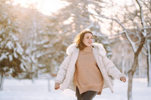 穿着冬衣的漂亮女人在雪地的公园里摆姿势 年轻的女士在一个阳光灿烂的冬天在森林里散步 冬季时尚 旅行概念 — 图库照片