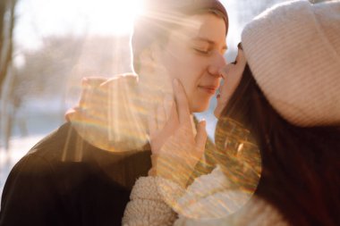 Sevgi dolu bir çift kar ormanında sarılıp öpüşüyor. Birlikte eğleniyoruz. Gençlik, aşk ve yaşam tarzı kavramı. Kış tatili.