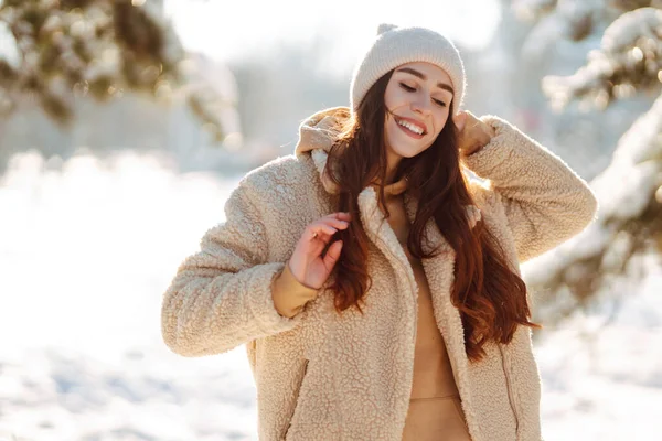 一个时髦的女人在雪地的公园里享受着冬季时光 穿着冬衣的年轻女子在外面欢快地摆姿势 寒冷的日子 生活方式和休闲概念 — 图库照片