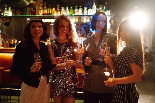 四个女朋友用火花和香槟庆祝圣诞节或新年 年轻女人喜欢用焰火狂欢 单身派对 — 图库照片