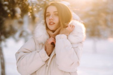 Karlı bir parkta poz veren güzel bir kadın. Soğuk hava. Kış modası, tatiller, dinlenme, seyahat konsepti.